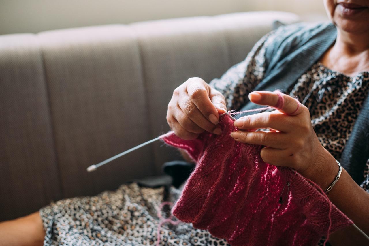 Person knitting while sitting down.