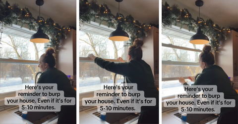 A woman opens her house to let some stale air out