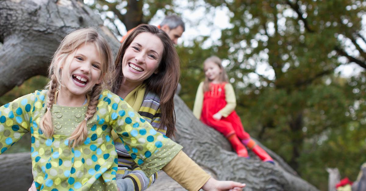 Family laughing on a tree branch