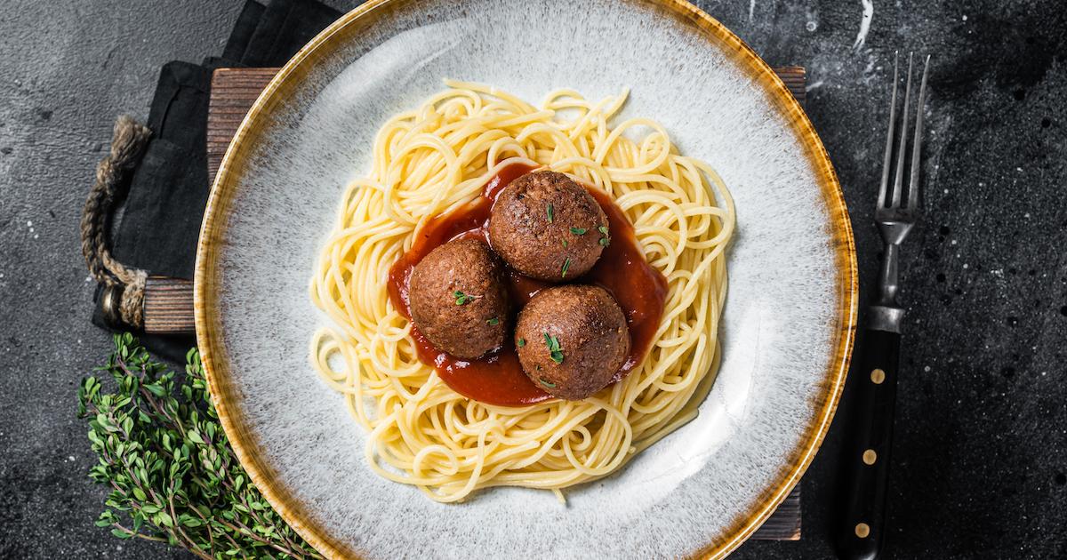 Spaghetti pasta with meatless meatballs and tomato sauce, from a top view.