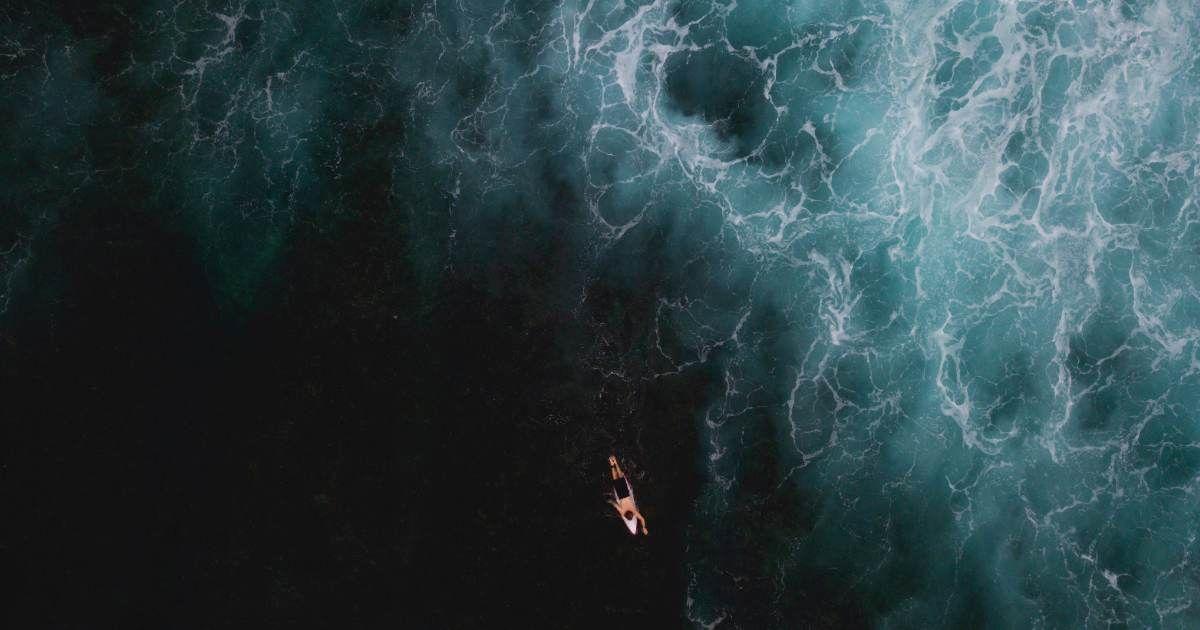 An aerial view of a lone surfer surfing in the vast ocean. (Representative Cover Image Source: Getty Images | Michael Duva)