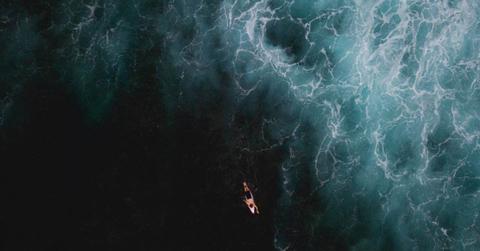 An aerial view of a lone surfer surfing in the vast ocean. (Representative Cover Image Source: Getty Images | Michael Duva)