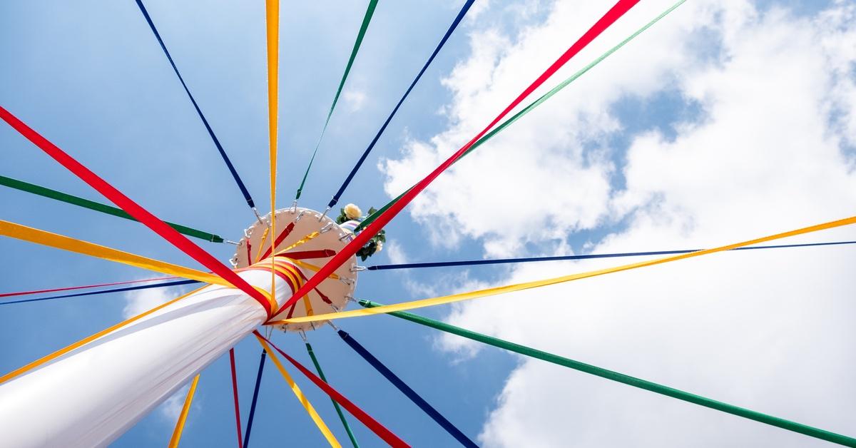 Multicolored May pole under a bright blue sunny sky. 