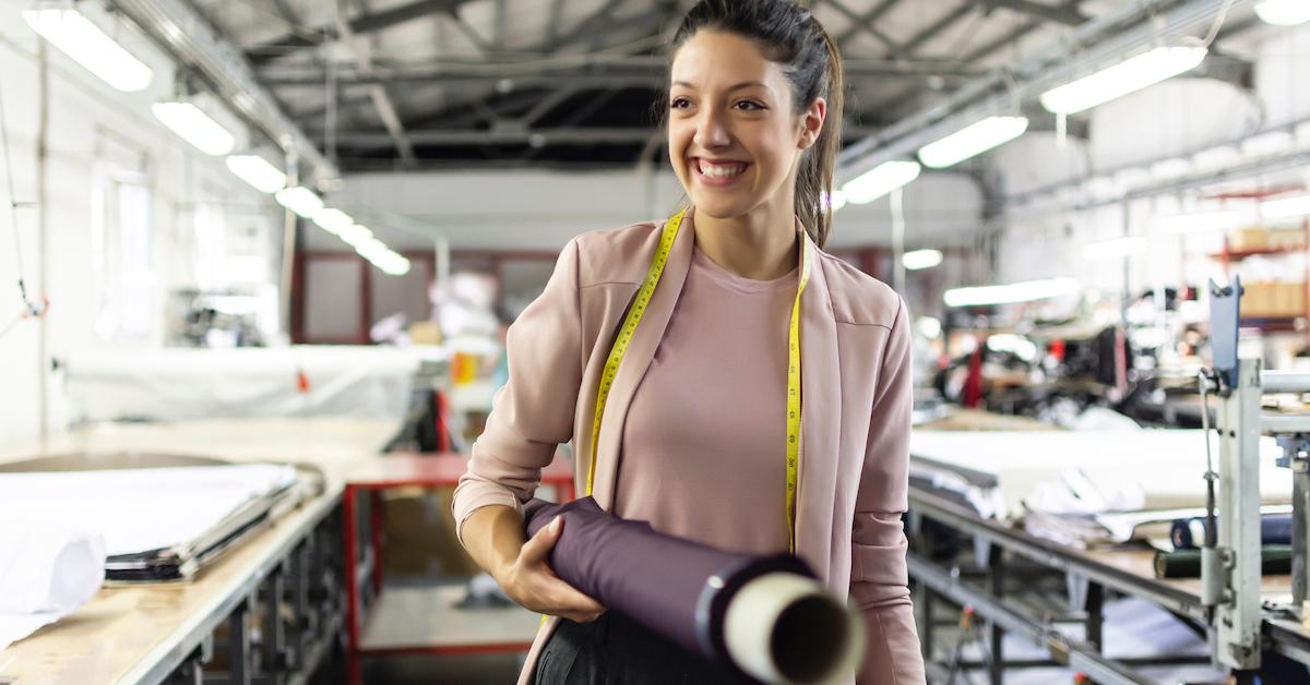 Woman at a clothing factory smiling.