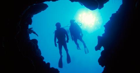 Two people scuba diving in the ocean.