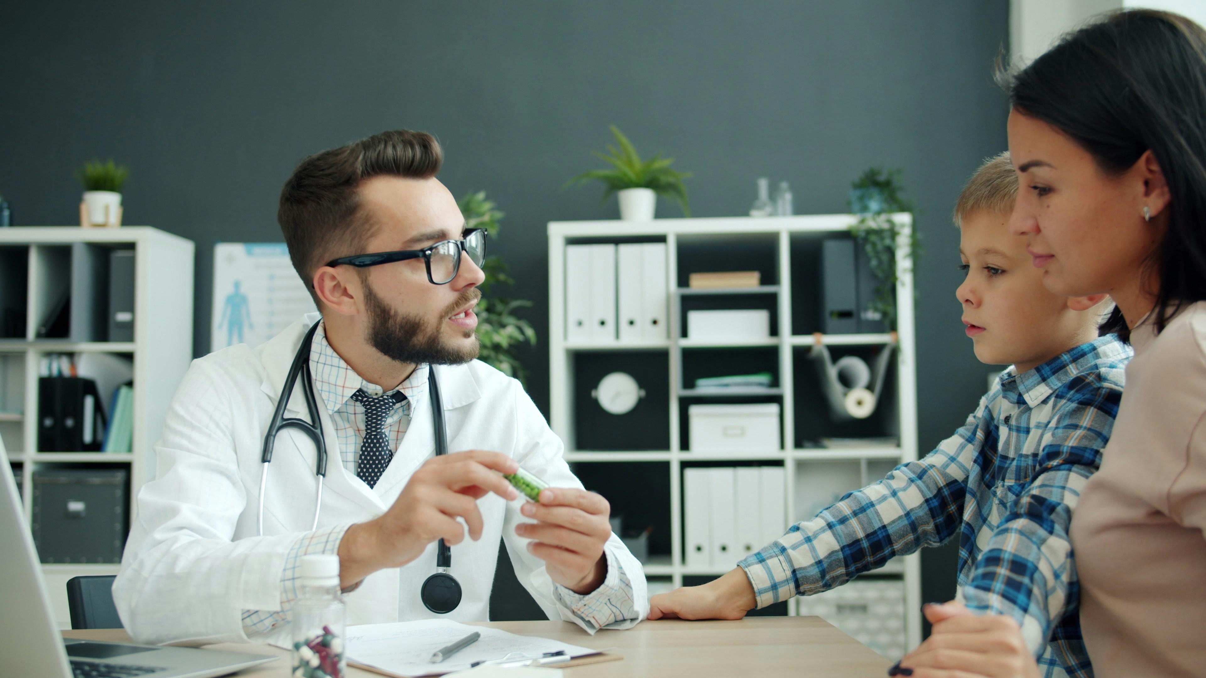 A doctor consults with a child patient and his mother.