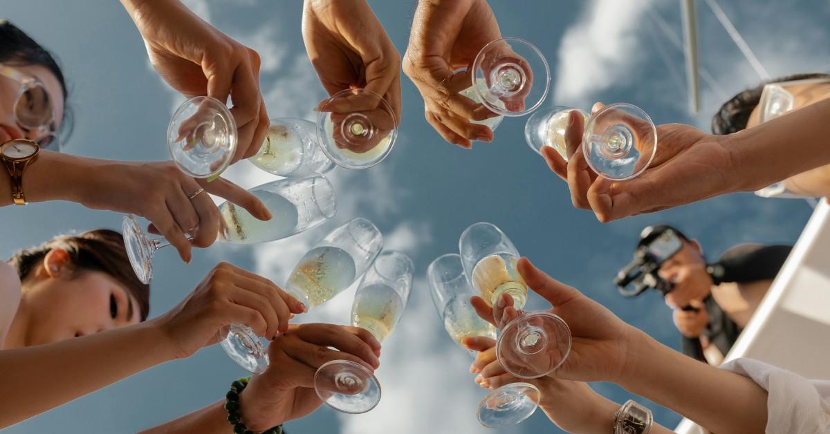 A worm's eye view of revelers toasting with champagne flutes