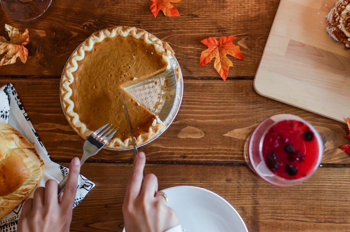 Aerial view of person cutting pumpkin pie