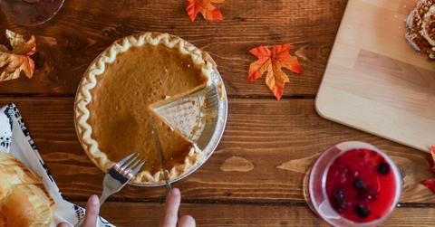 Aerial view of person cutting pumpkin pie