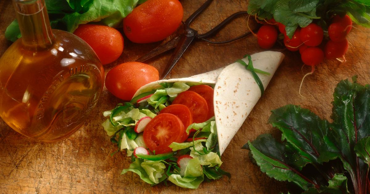 Wrap with lettuce, tomatoes and tortilla on a table. 