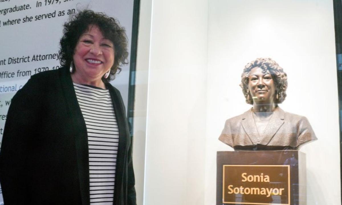 Supreme court justice Sonia Sotomayor poses with a bust of herself. 