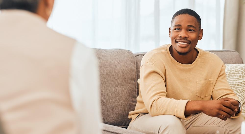 A man in a therapy session across from a therapist. 