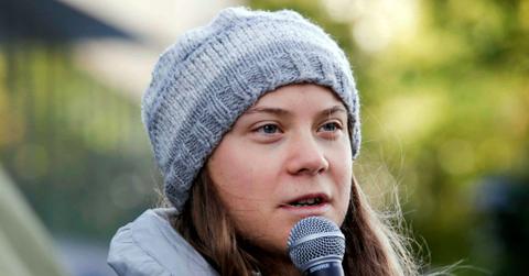 Swedish environmental activist Greta Thunberg, wearing a gray beanie, delivers a speech outside the seat of the Statkraft energy company in Oslo, Norway in October 2023.