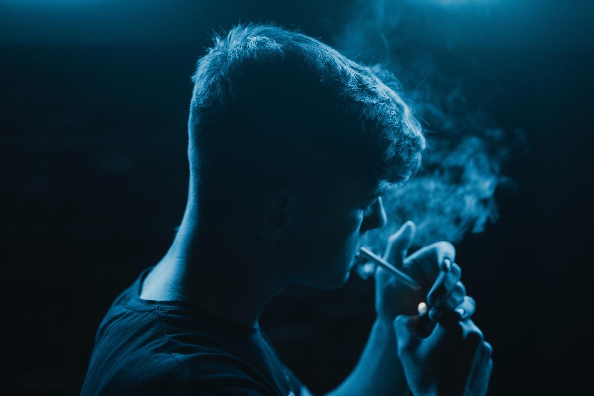 young man smoking in the dark