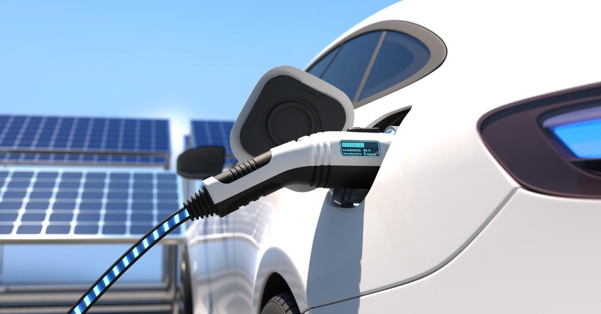 An electric vehicle charging in front of solar panels.