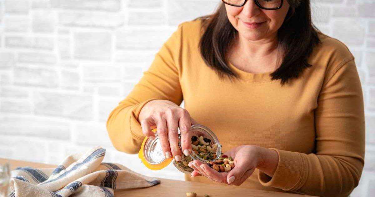 Woman snacking on a trail mix of nuts and seeds (Representative Cover Image Source: Getty Images | FCafotodigital)