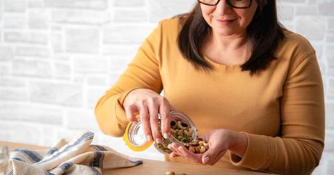Woman snacking on a trail mix of nuts and seeds (Representative Cover Image Source: Getty Images | FCafotodigital)