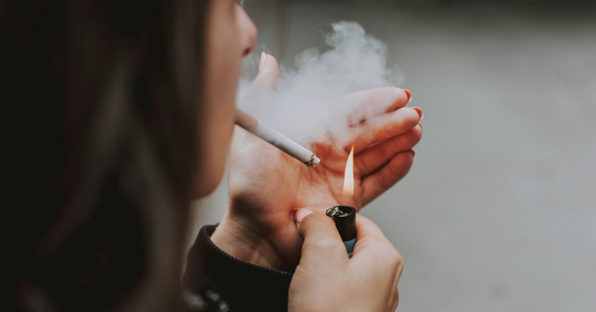 A woman lights a cigarette