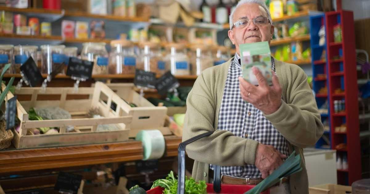 A shopper checking the label on a product in grocery store. (Representative Cover Image Source: Pexels | Kampus Productions)