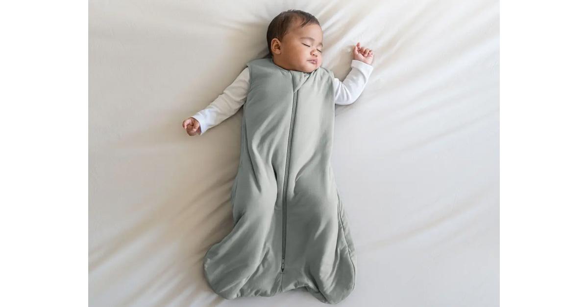 baby sleeping in a soft green wearable blanket