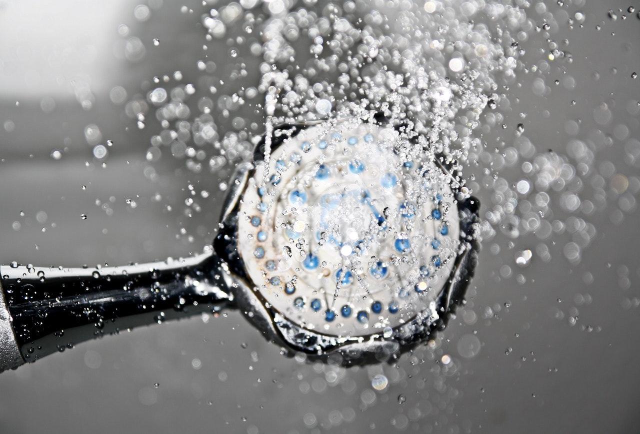 A shower head with the water running. 