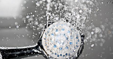 A shower head with the water running.