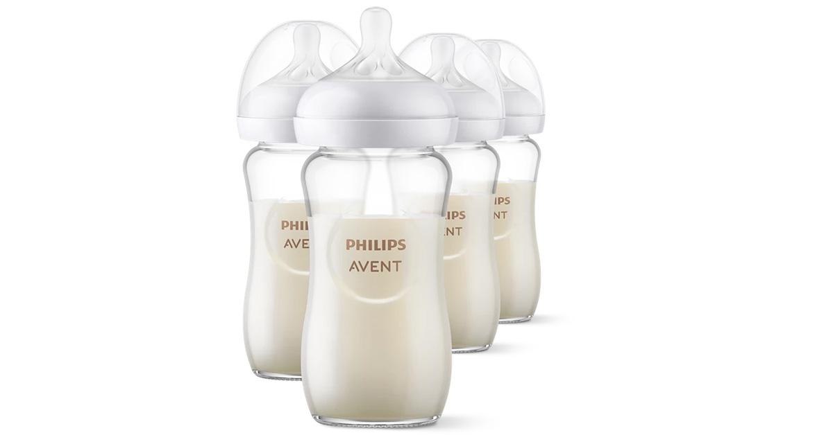 Four glass baby bottles with milk inside