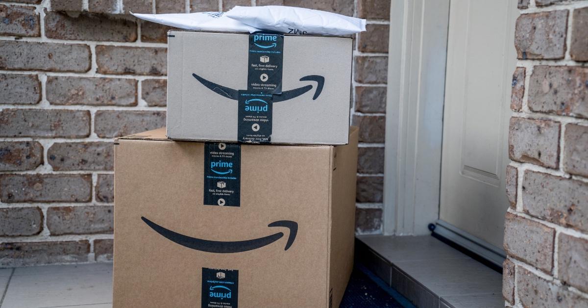 Packages stacked atop one another outside of a front door from amazon prime. 