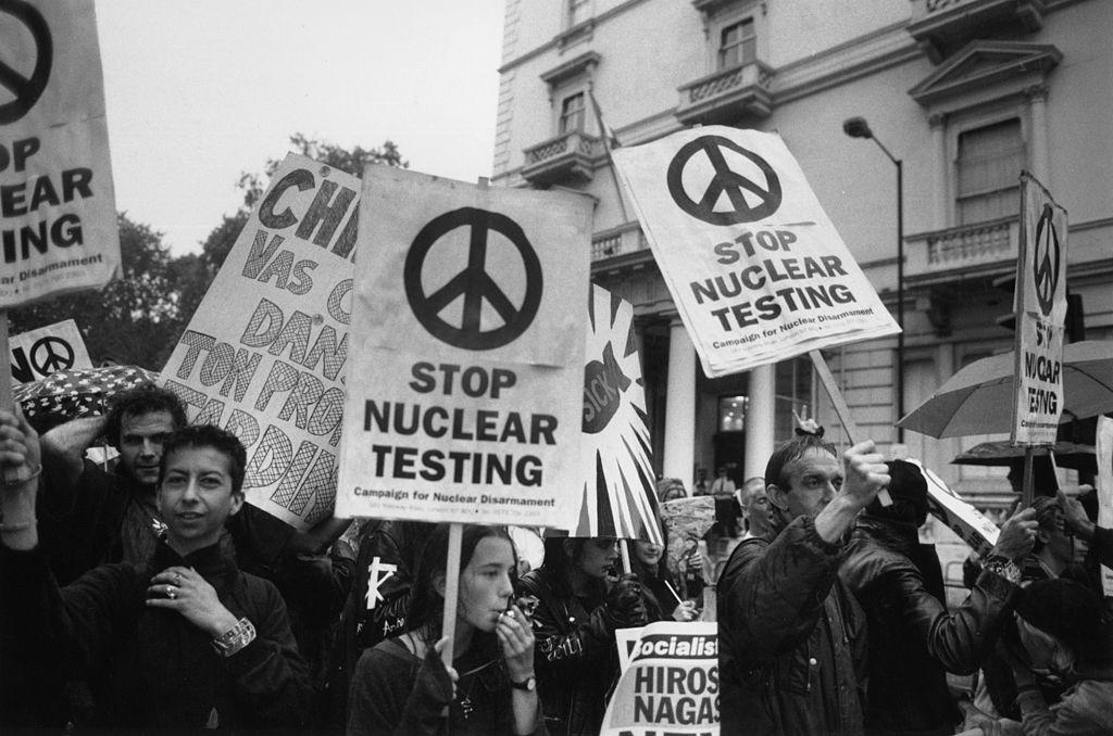 Protestors holding up "stop nuclear testing" signs