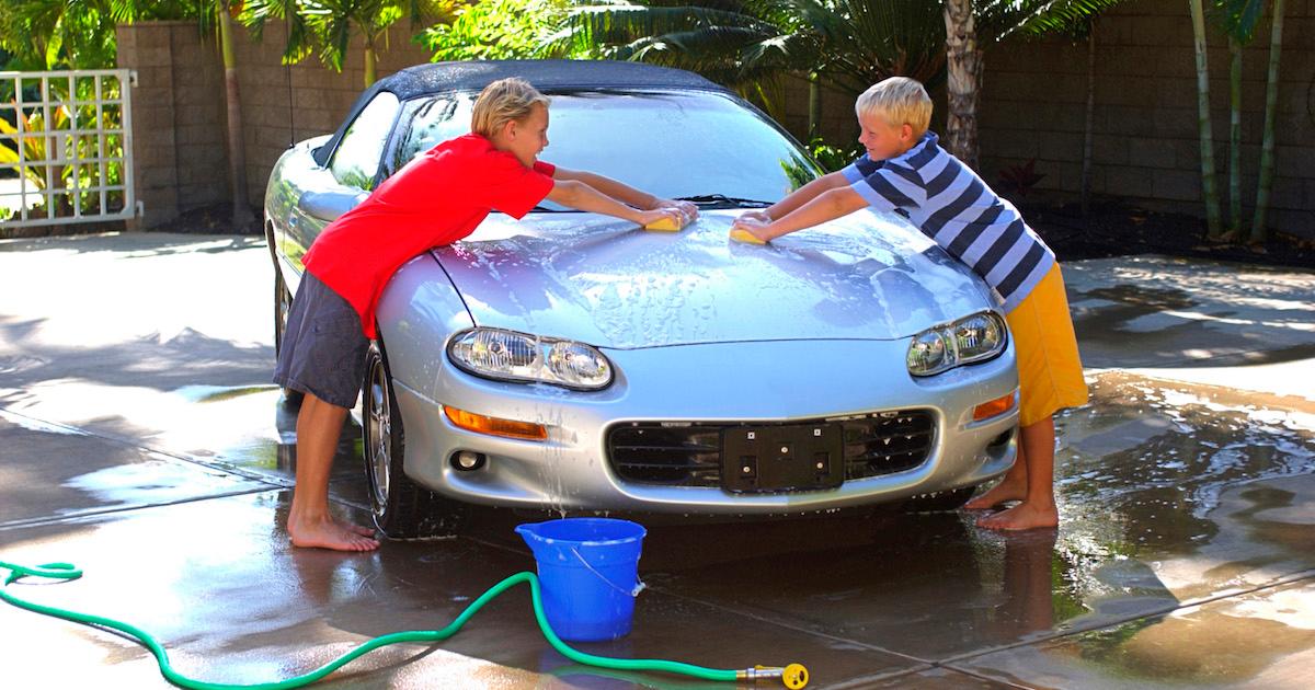 Kids washing a car at home