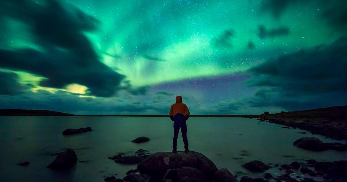 A man admiring the Northern Lights aurora in the Arctic. (Representative Cover Image Source: Getty Images | Westend61)