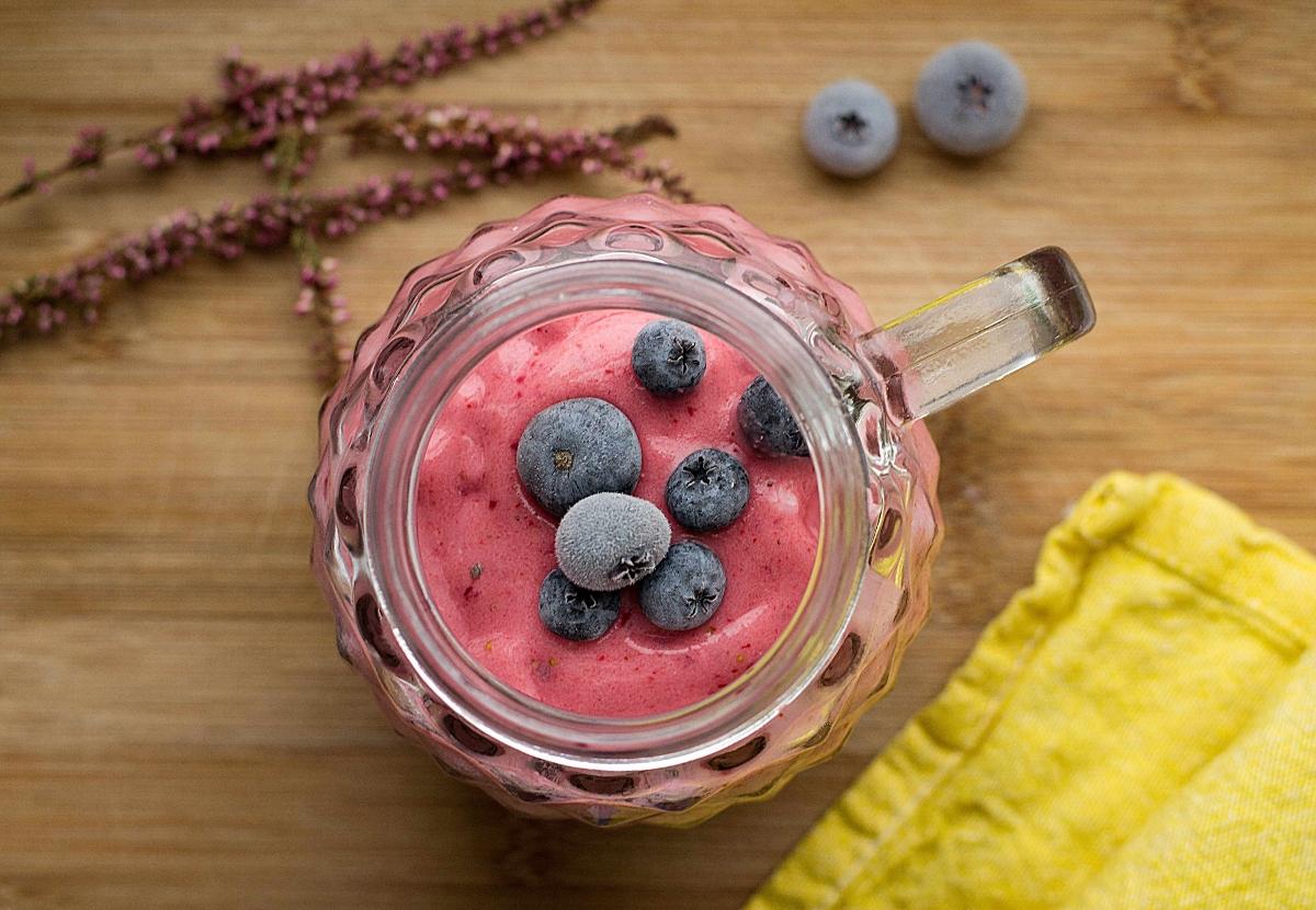 aerial view of pink berry smoothie with blueberries on top