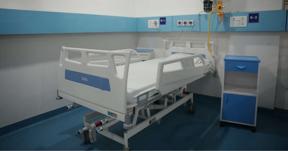 An empty hospital bed sits in an emergency room