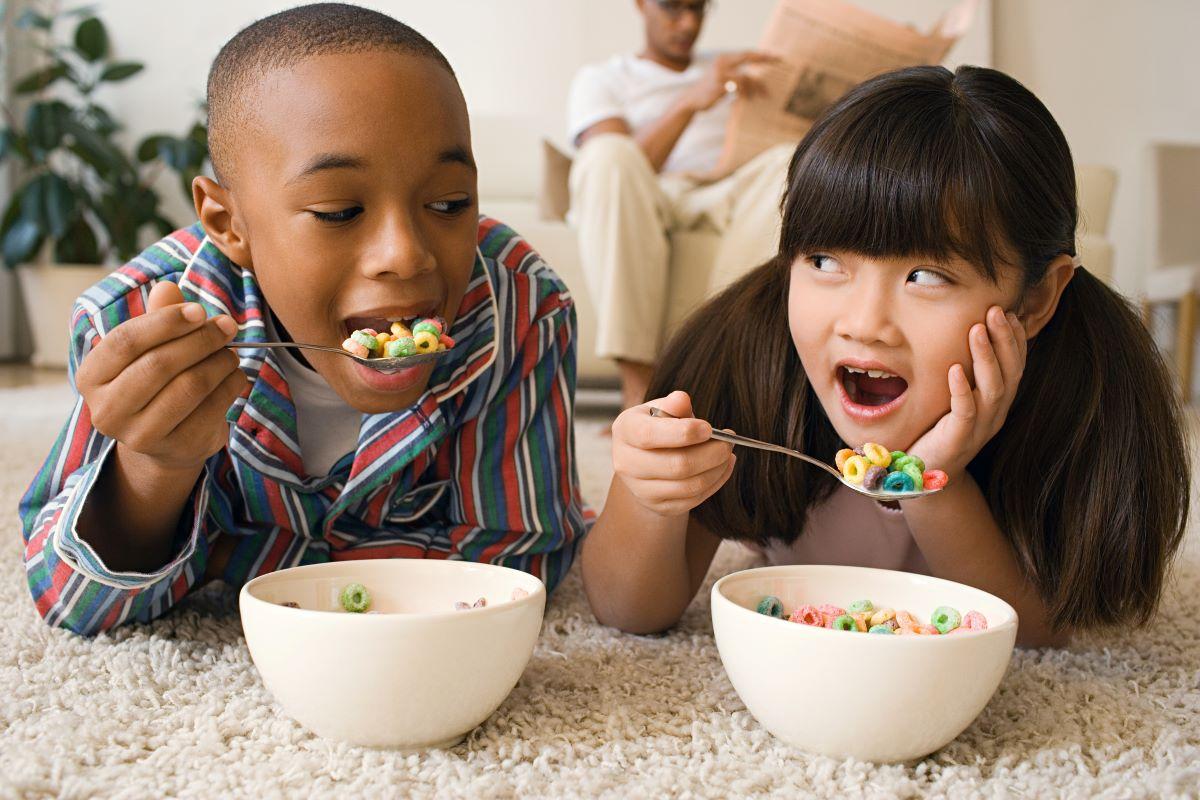 Children eating sugar cereal on the carpet