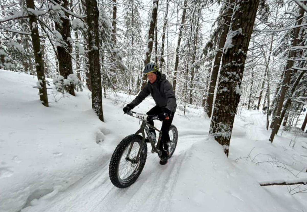 man cycling on snowy trails