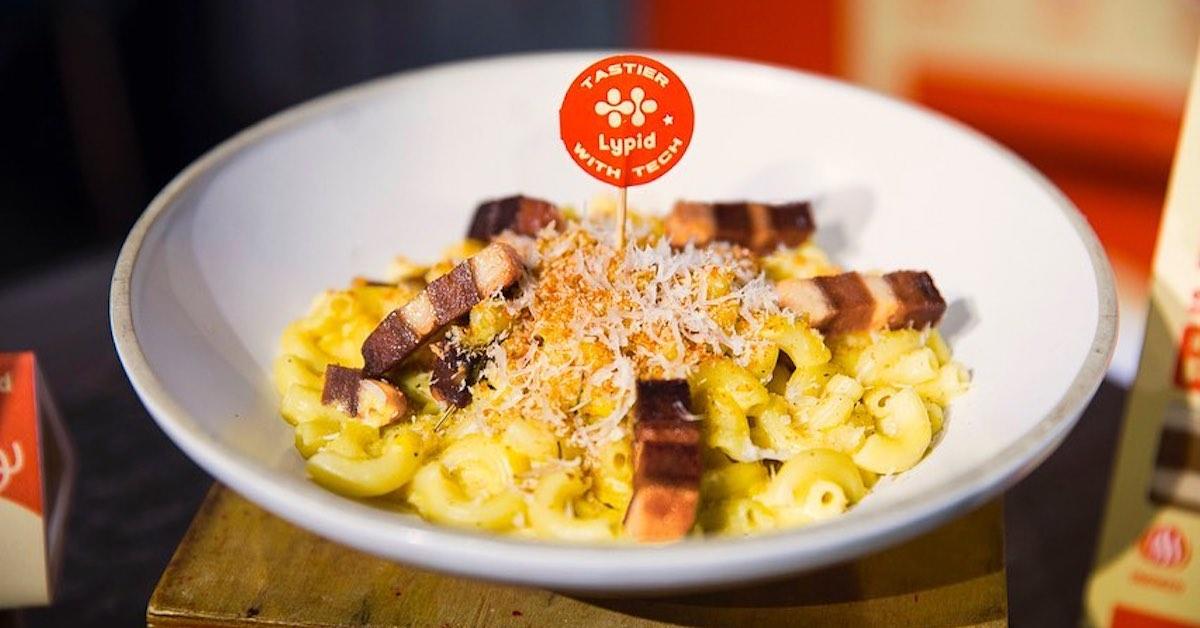 A dish with mac and cheese topped with Lypid's vegan pork belly