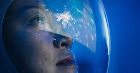 Astronaut looking through the window of a spaceship (Representative Cover Image Source: Getty Images | CG Tan)
