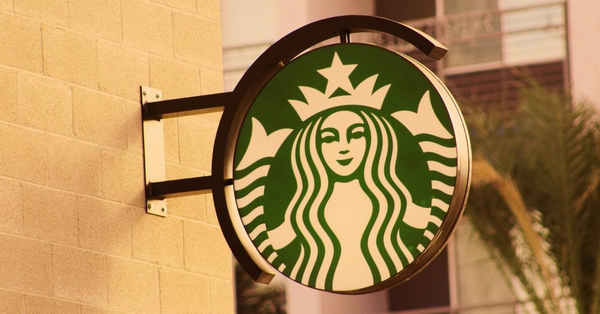 The Starbucks logo hangs suspended from a brick storefront