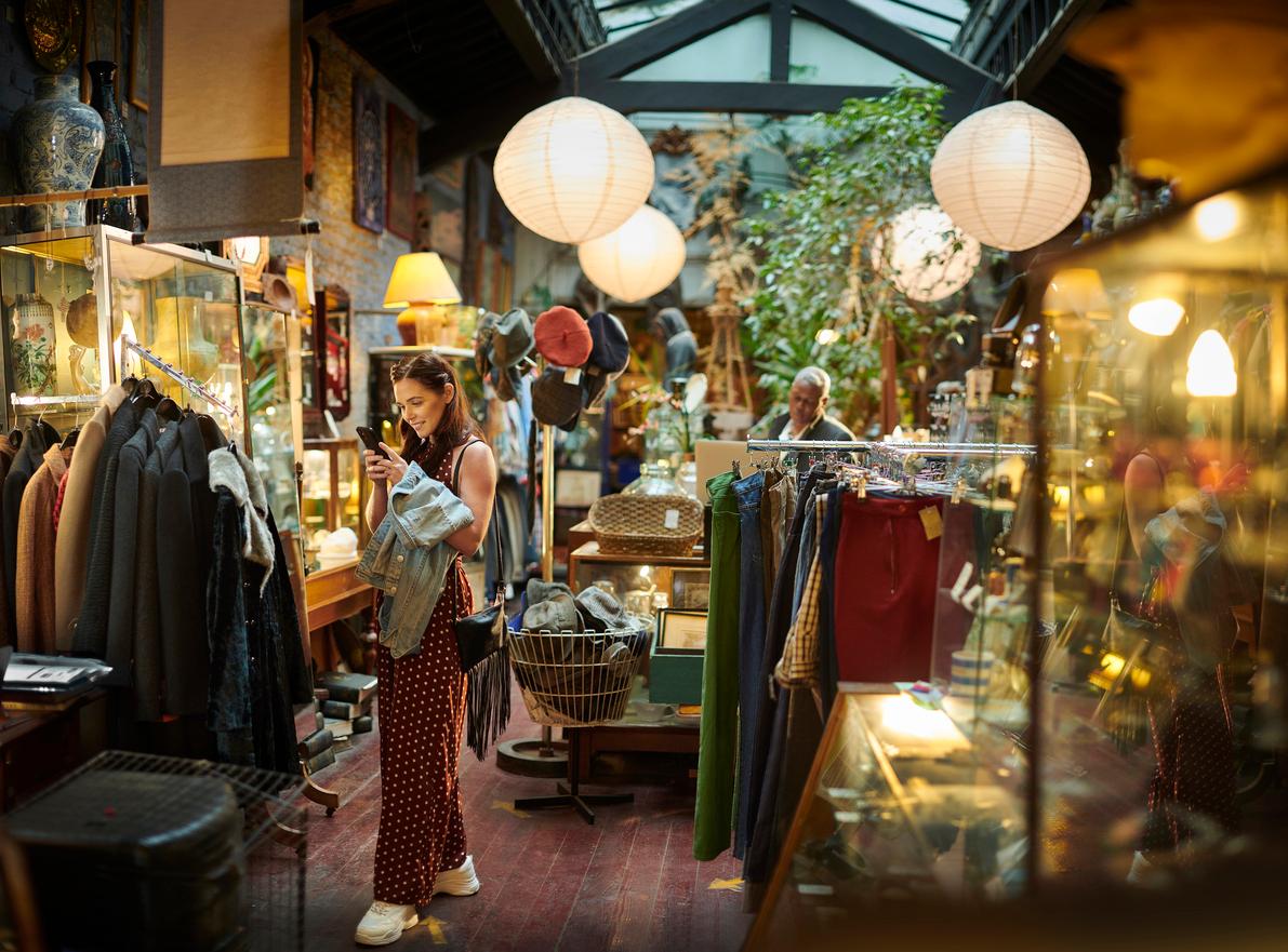 Shoppers inside a thrift store browse for clothes and jewelry.