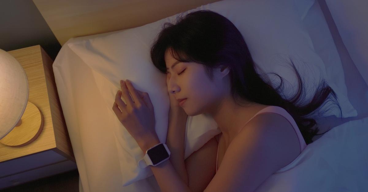 Woman with a smart watch sleeping with a light on.