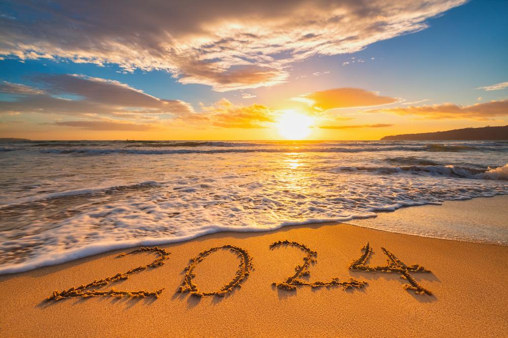 A beach in Hawaii with "2024" in the sand.