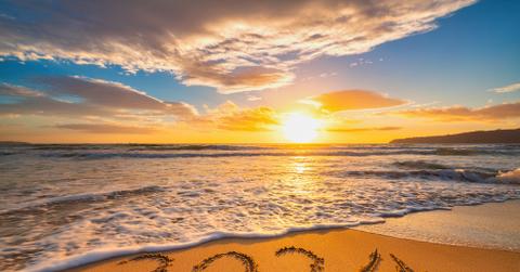 A beach in Hawaii with "2024" in the sand.