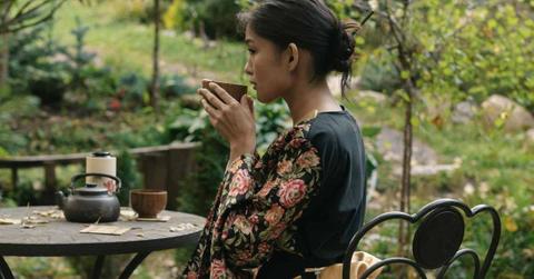 A woman dressed up in a traditional Japanese robe peacefully drinks tea in her garden. (Representative Cover Image Source: Pexels | Mikhail Nilov)