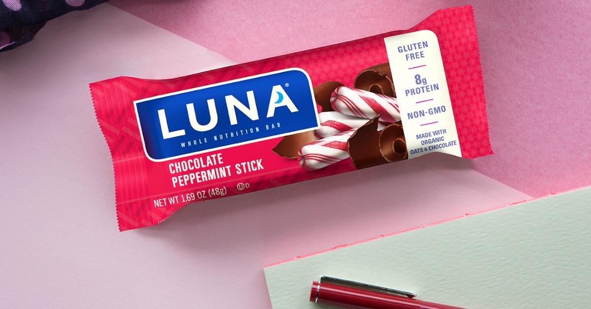 Chocolate Peppermint Stick Luna Bar on a pink piece of paper with a notebook and pen.