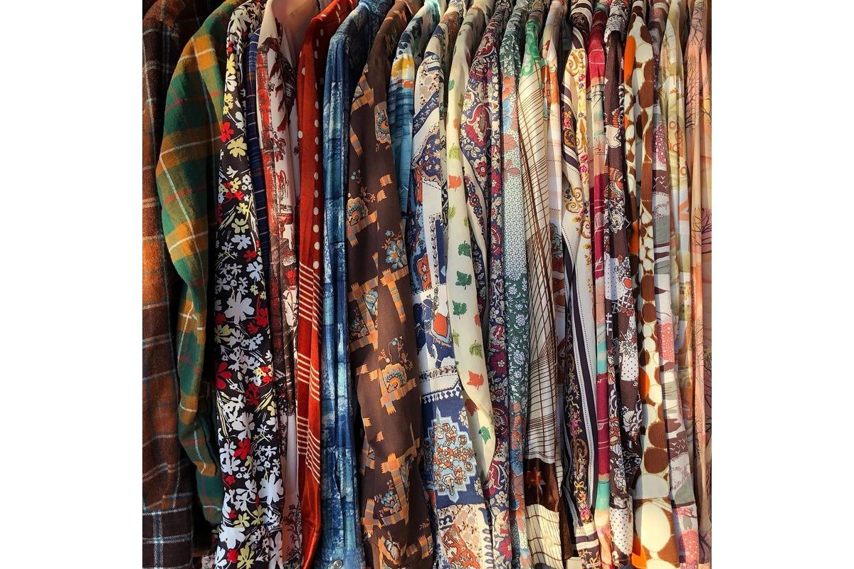 A clothing rack with colorful shirts at Rare Bird Vintage