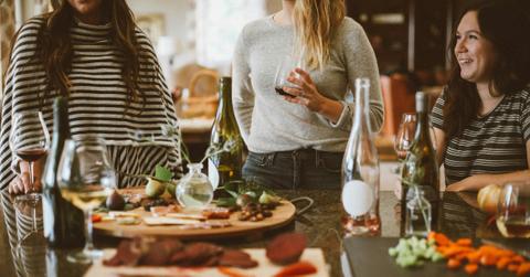 Three women gather around a table at a party