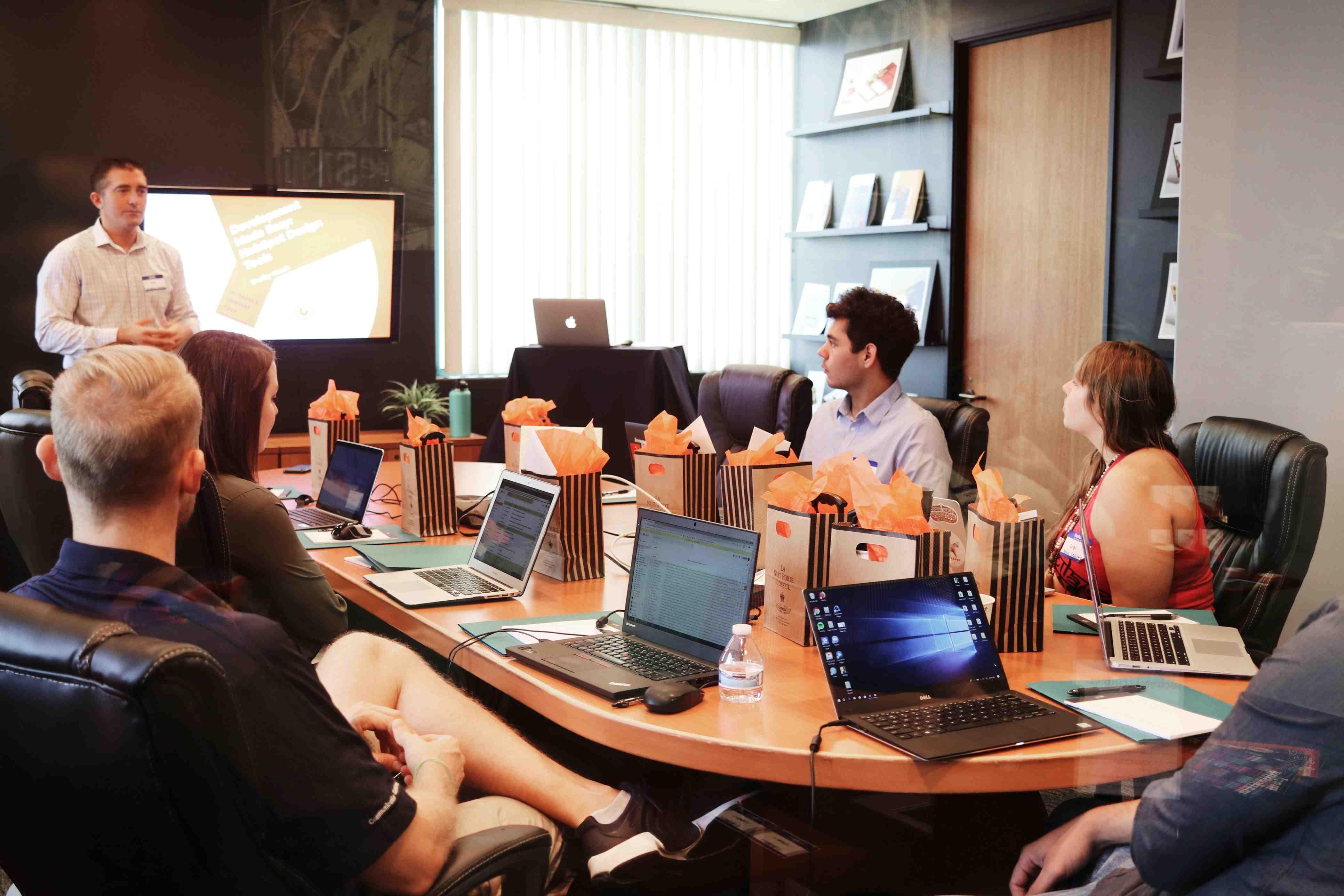Employees attend a work meeting in a conference room.