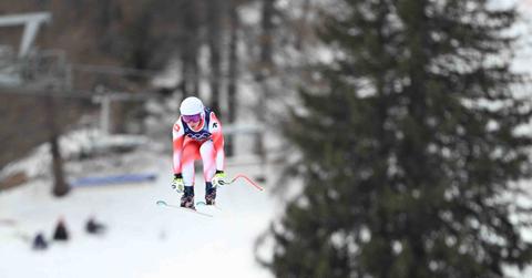 A Swiss Olympic skier is pictured midair on the Tofane Alpine Skiing Centre course in Cortina, Italy on Feb. 10 at the 2026 Winter Olympic Games.