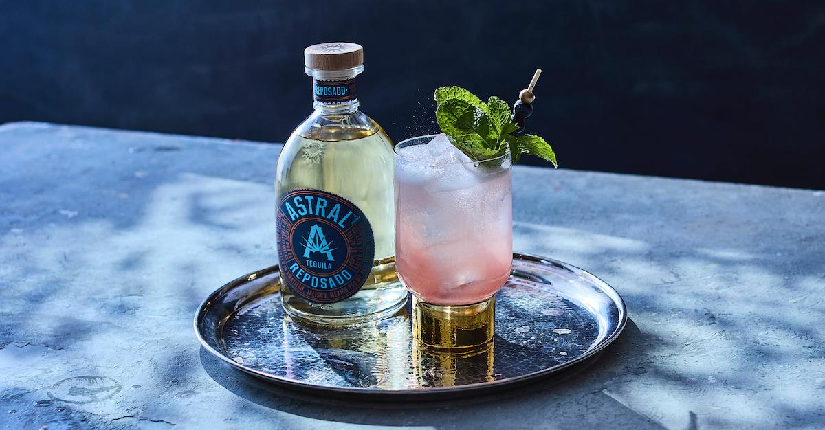 An Astral Nebula on a silver tray with a bottle of Astral Tequila.