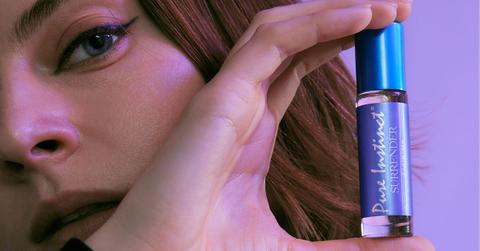 Close-up photo of woman holding Pure Instinct's Surrender Roll-On Pheromone Perfume Oil